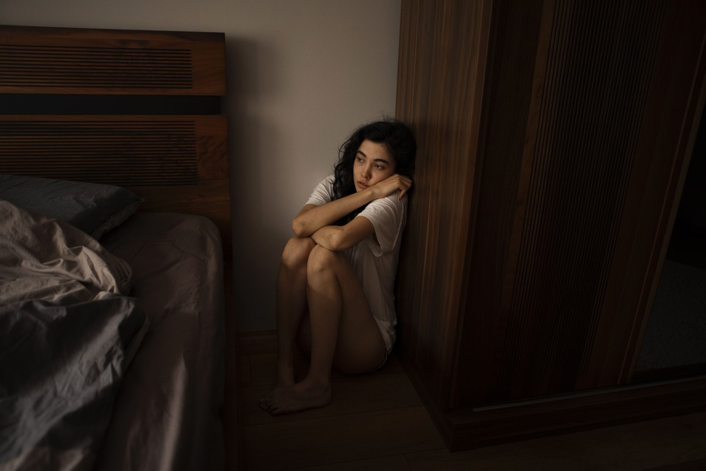 Mulher No Canto Do Quarto Com Expressão Triste E Sinais De Depressão